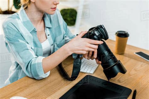 Cropped Shot Of Young Female Photographer Working With Camera In Office