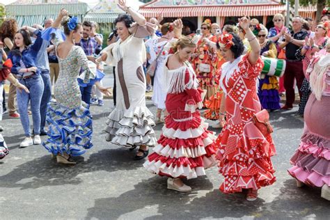 Young Women Wearing Flamenco Dresses And Dancing Sevillanas At The