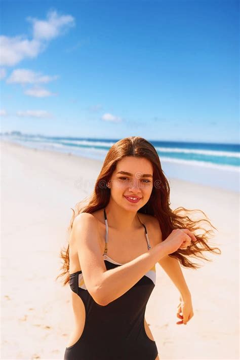 Portrait Of Confident Woman In Bikini Running On Beach Stock Photo