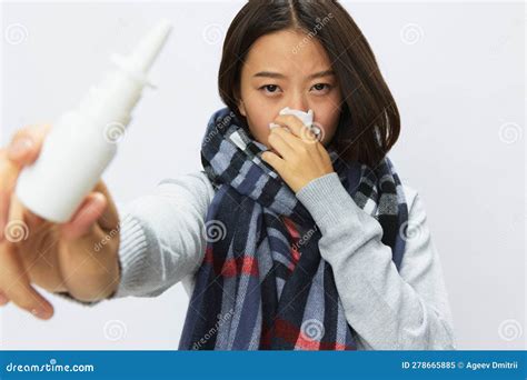 Asian Woman With A Cold With A Stuffy Nose Holding A Nasal Spray For Allergies With A Sore