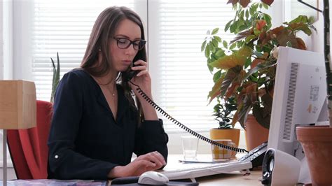 Female Receptionist Working On Computer And Talking On Phone Home Office Teleworking Remote