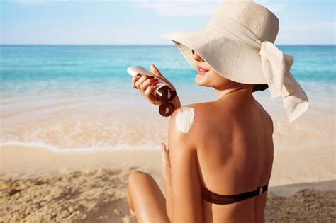 Premium Photo Beautiful Woman In Bikini Applying Sun Cream On Tanned Shoulder Sun Protection