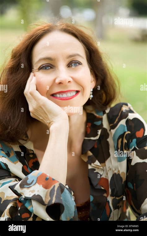 Portrait Of A Middle Age Woman Wearing A Hearing Aid Smiling In The