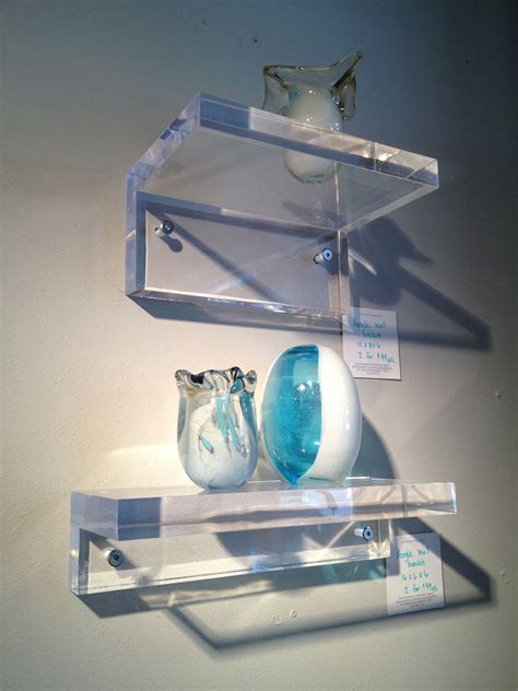 Two Glass Vases Sitting On Top Of A Shelf