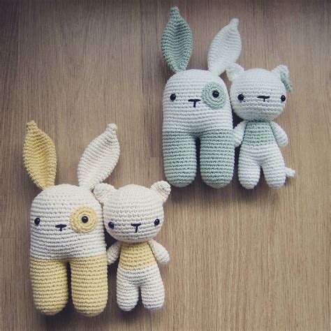 Three Crocheted Stuffed Animals Sitting Next To Each Other On A Wooden