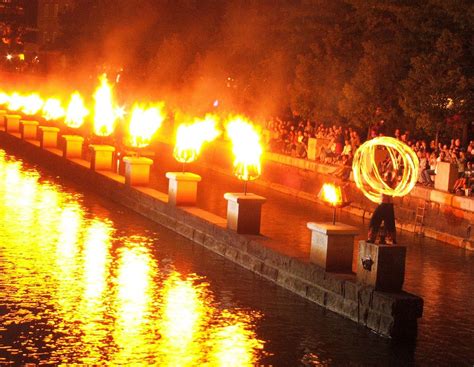 Bonfires sparkle above the water that snakes through. A view from 'Waterfire' in Providence, RI. | River boat ...