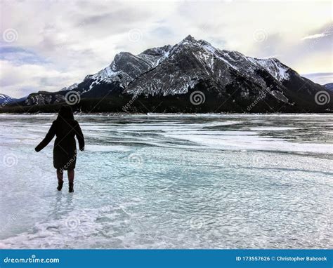 A Woman Walking On And Towards A Frozen Lake In A Beautiful Winter