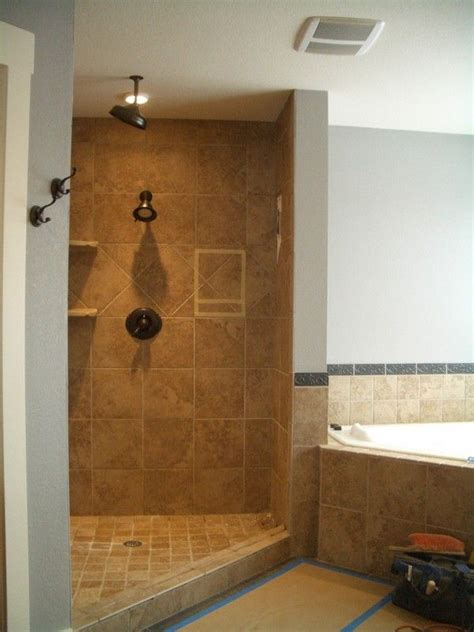 A Walk In Shower Sitting Next To A Bath Tub