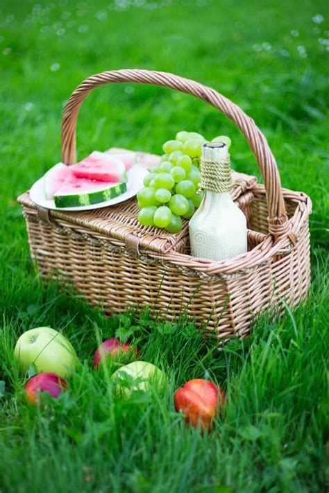 Picnic Basket With Fruits And Bottle Of Wine On Green Grass Stock Photo