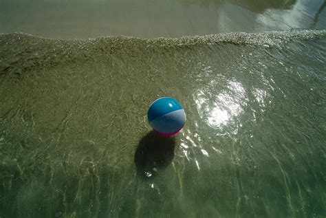 Beach Ball Floating In The Surf Photograph By Todd Gipstein