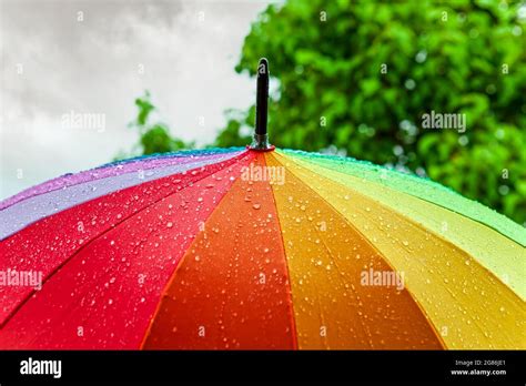 Rain On Rainbow Umbrella Umbrella Under Heavy Rain Against Cloudy Sky