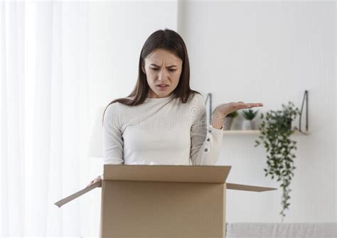 Disappointed Woman Receive Damaged Wrong Parcel At Home Stock Photo