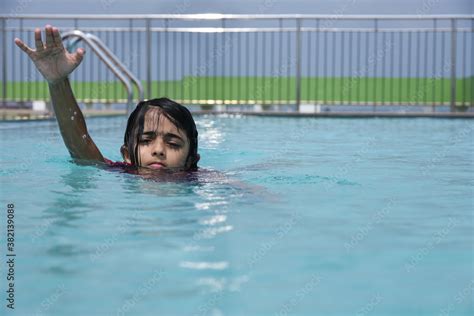 Small Indian Girl Swimming Or Learning To Swim Splashing Water In Swimming Pool In Kerala