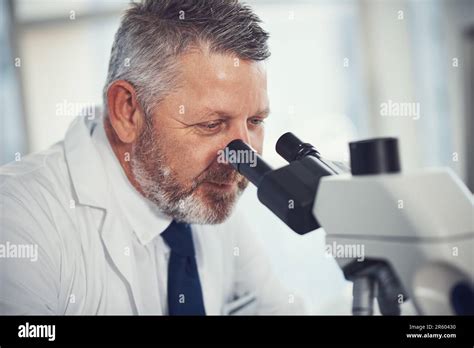 Making medical magic happen. a mature scientist using a microscope in a