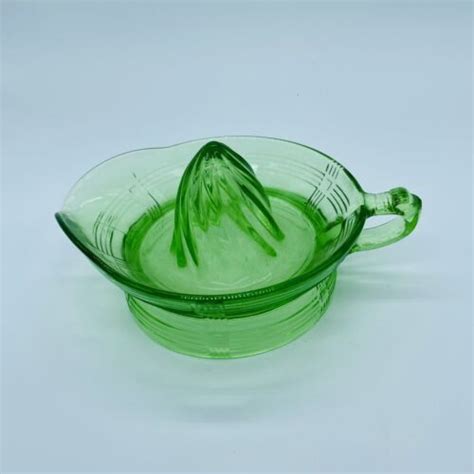 A Green Glass Bowl Sitting On Top Of A White Table