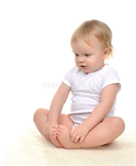 Infant Child Baby Toddler Kid Sitting On Carpet And Looking Down Stock