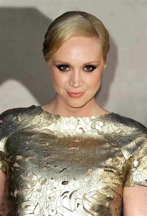 A Woman With Blonde Hair Wearing A Gold Dress