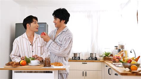 Happy Gay Couple Enjoy Breakfast In Kitchen Drinking Coffee Two Best Friends Lgbtq Relation