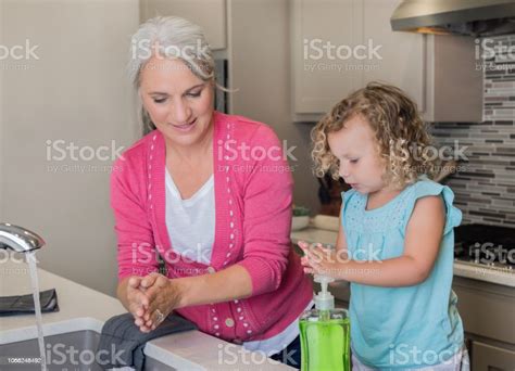 Grandmother Teaching Preschool Age Granddaughter To Wash Hands With
