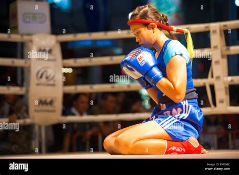 Female Muay Thai Fighter Kneeling Gloves Raised Reflecting In A