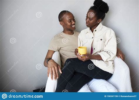 Smiling Happy Dark Skinned Couple Relaxing At Home Stock Photo Image