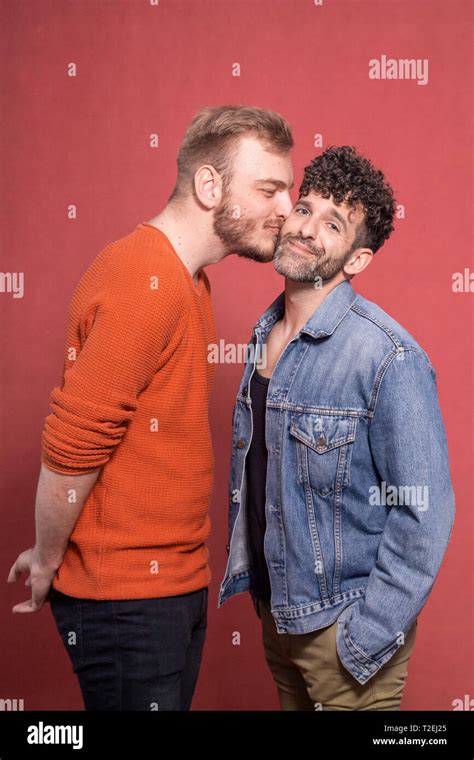 Two Men Gay Couple Intimate Kiss On Cheek One Is Looking To Camera