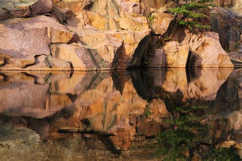 Granite Cliffs And Reflections In A Quarry Lake Photograph By Greg