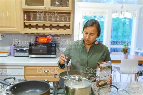 Native American Woman Cooking Dinner At Home Stock Photo Download