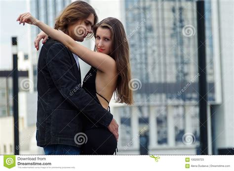 Beautiful Sensual Elegant Couple Stands On A City Street And Embraces