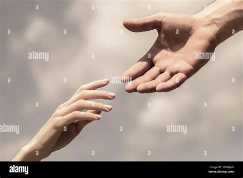 Giving A Helping Hand Hands Of Man And Woman On Blue Sky Background