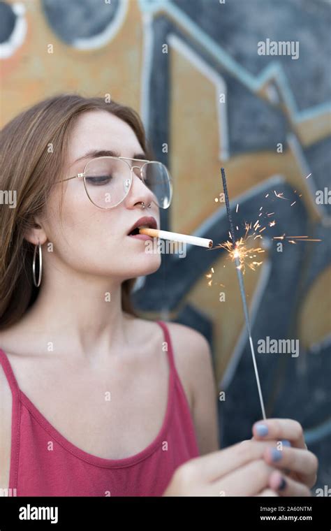 Young Woman Lighting Cigarette With A Sparkler Stock Photo Alamy