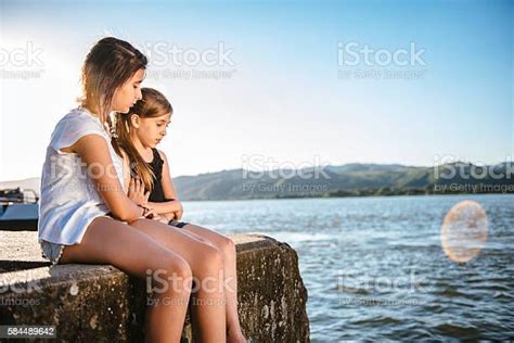Girl Comforting Her Sad Friend On Dock Stock Photo Download Image Now