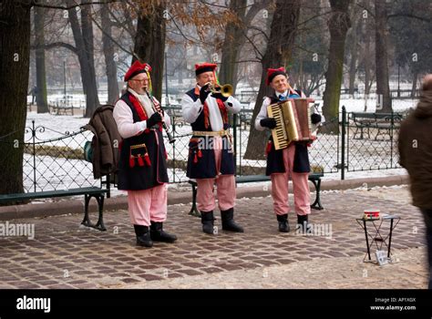 los músicos folklóricos cracovian en coloridos trajes tradicionales típicos jugando en el