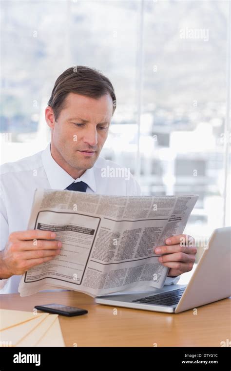 Serious Businessman Reading A Newspaper Stock Photo Alamy