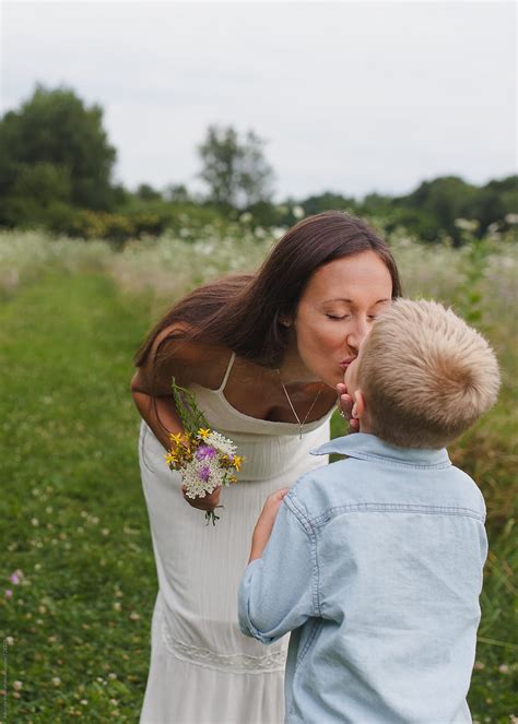 Mother Kisses Son After He Gives Her A Bouquet Of Wildflowers By Stocksy Contributor Amanda