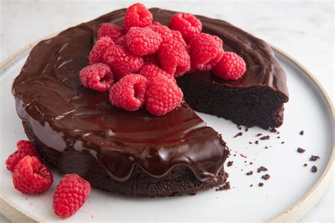 A Chocolate Cake Topped With Raspberries On A Plate
