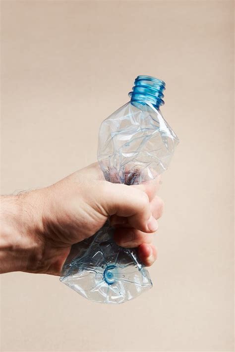Botella De Plástico Aplastado Con Mano Masculina Imagen De Archivo