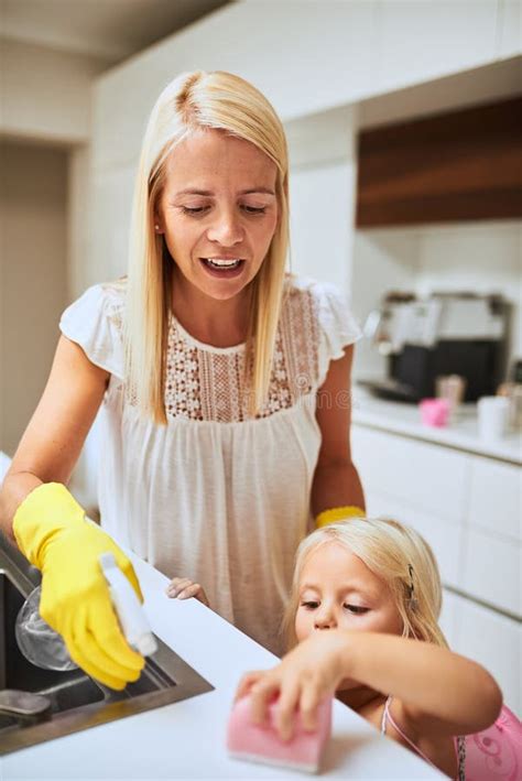 Helping Mom Get The Housework Done A Mother And Her Little Daughter Cleaning A Kitchen Surface