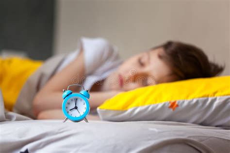 Focus On Alarm Clock Child Sleeping In Bed On Pillow With Alarm Clock