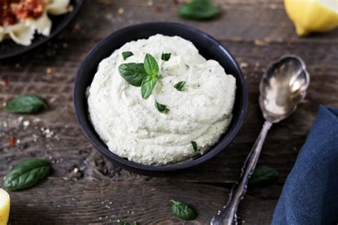 Vegan Ricotta Cheese In A Small Black Bowl And Topped With Fresh Basil