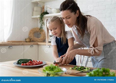 Mamá Enseña A Las Hijas A Cocinar En La Cocina Foto De Archivo Imagen