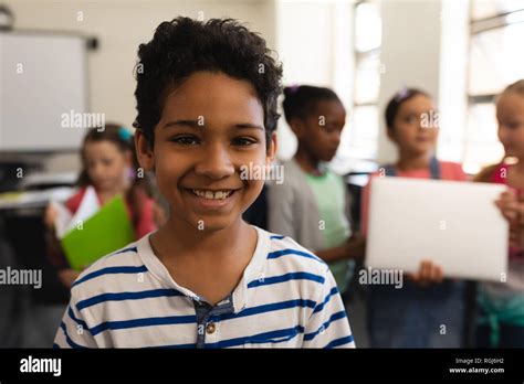 Close Up Of Happy Schoolboy Looking At Camera In Classroom Of