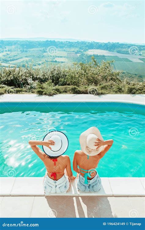 Two Girls Sitting By The Pool Relaxing Having Fun Stock Image Image