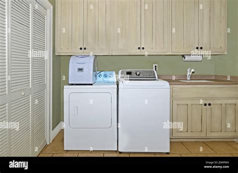 A Laundry Room With Washerdryerice Makersinkcabinetsand A Pantry Area The Cabinets Have A