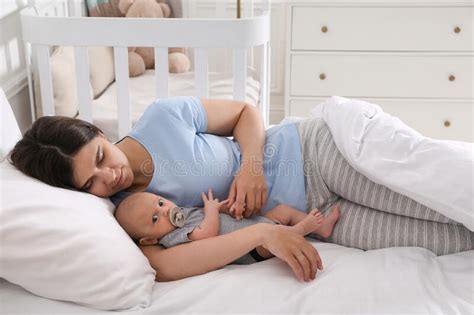 Tired Young Mother Sleeping With Her Baby In Bed Stock Photo Image Of