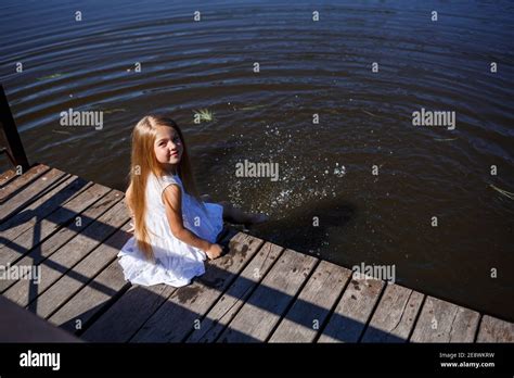 Ein 7 Jähriges Mädchen Mit Langen Blonden Haaren Am See Sitzt Auf Einer