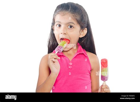 Happy kid girl eating ice cream in studio isolated hi-res stock