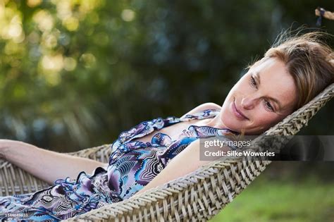 Portrait Of A Content Handsome Mature Woman Laying In Her Hammock In Her Garden High Res Stock