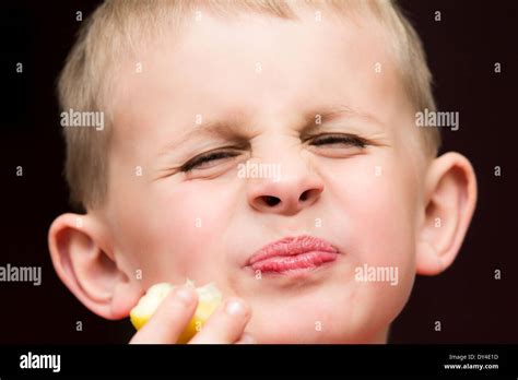 Young Boy With Pursed Lips For Eating A Lemon Stock Photo Alamy