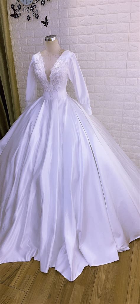 This wedding gown has an unique lace decoration, which designed in different on the product details: Minimalist long sleeves royal white satin ball gown ...